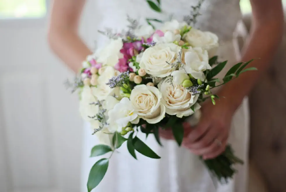 A bride holding a white and pink bridal bouquet